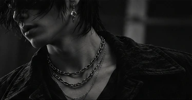 Layered silver-tone jewelry and dark textures
