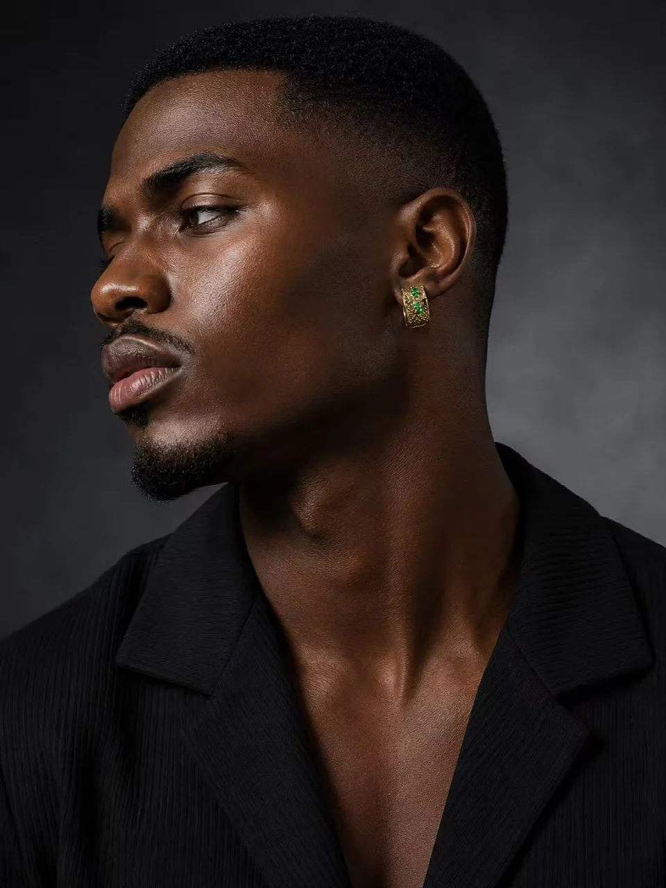 Profile portrait with a textured gold-tone earring and green accents