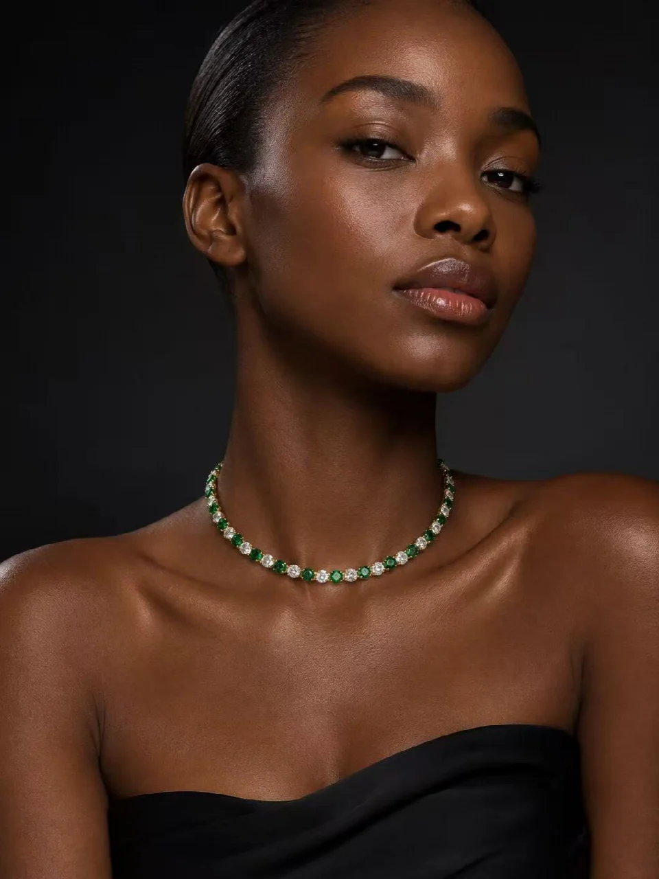 Portrait wearing a necklace with green and clear accents
